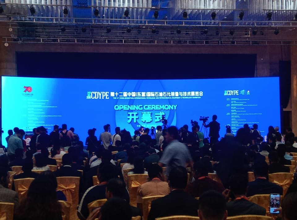 观众站在大屏幕前，屏幕上显示“Opening Ceremony, 12th CDYPE”。